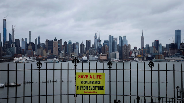 File photo: A sign promoting social distancing hangs from a fence in Hamilton Park above the Hudson River with the New York City skyline of Manhattan in the background, during the outbreak of the coronavirus disease (COVID-19), in Weehawken, New Jersey, U.S., April 3, 2020