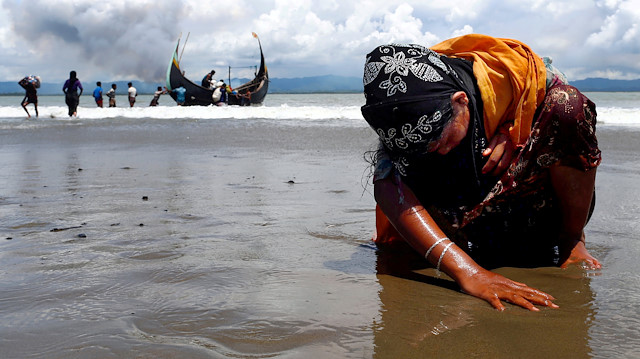 An exhausted Rohingya refugee woman touches the shore after crossing the Bangladesh-Myanmar border by boat through the Bay of Bengal in Shah Porir Dwip, Bangladesh, September 11, 2017. Picture taken September 11, 2017. REUTERS/Danish Siddiqui/File Photo SEARCH "POY DECADE" FOR THIS STORY. SEARCH "REUTERS POY" FOR ALL BEST OF 2019 PACKAGES. TPX IMAGES OF THE DAY.

