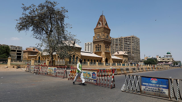 A traffic police officer walks past barriers used to block the road in front of the British era Empress Market building, during a lockdown after Pakistan shut all markets, public places and discouraged large gatherings amid an outbreak of coronavirus disease (COVID-19), in Karachi, Pakistan April 3, 2020. REUTERS/Akhtar Soomro

