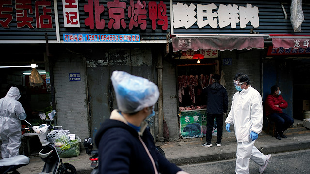 File photo: People wearing protective suits is seen at a street market in Wuhan, Hubei province, the epicentre of China's novel coronavirus disease (COVID-19) outbreak, April 6, 2020