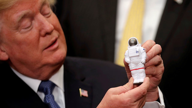 FILE PHOTO: U.S. President Donald Trump holds a space astronaut toy as he participates in a signing ceremony for Space Policy Directive at the White House in Washington D.C., U.S., December 11, 2017. 