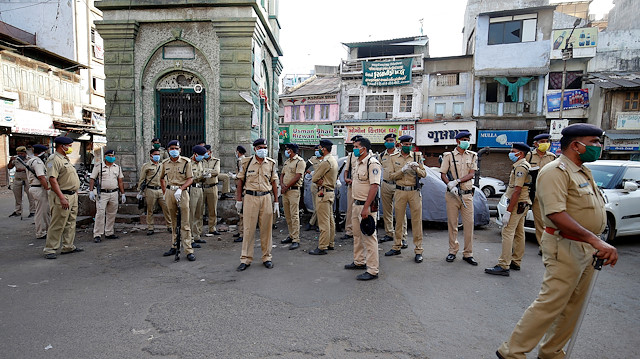 Policemen wearing protective masks stand guard in a neighborhood during a lockdown in the area after dozens of men were taken to a quarantine facility amid concerns about the spread of coronavirus disease (COVID-19), in Ahmedabad, India, April 6, 2020