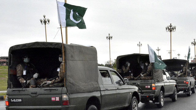 Pakistan's national flags flutter on an army convoy patrolling during a partial lockdown