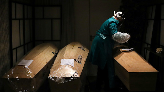 A mortuary worker is pictured amid coffins, during the coronavirus disease (COVID-19) 