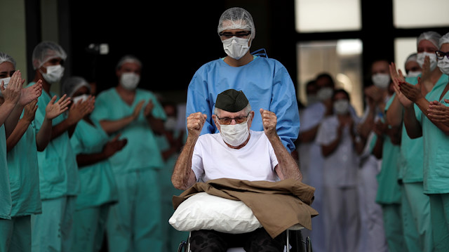Brazilian 99-year-old former WWII combatant Ermando Armelino Piveta, gestures as leaves the Armed Forces Hospital in Brasilia, after being treated for the novel coronavirus (COVID-19) and discharged, amid the coronavirus disease (COVID-19) outbreak, in Brasilia, Brazil, April 14, 2020. 