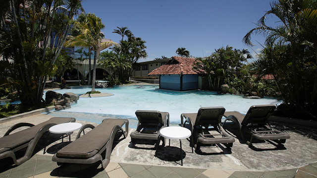 Empty sunbathing chairs are seen near a pool in a hotel in Costa Rica