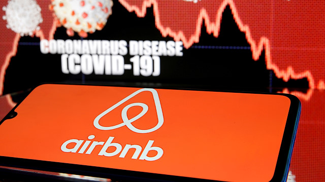 FILE PHOTO: Airbnb logo is seen in front of diplayed coronavirus disease (COVID-19) in this illustration taken March 19, 2020