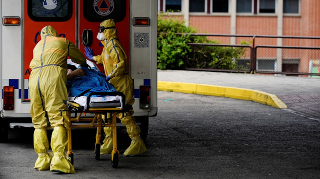 Healthcare workers push a patient on a stretcher at the emergency unit at Severo Ochoa 