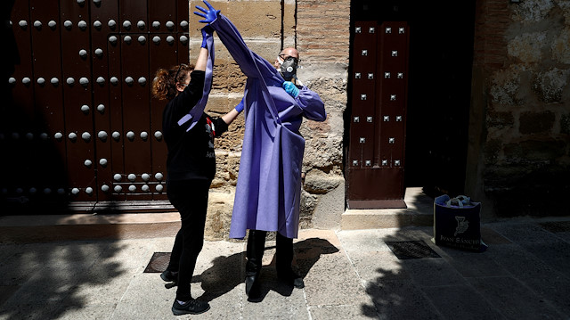 Priest Andres Conde, 49, receives help from his twin sister Inma while donning personal protective equipment he received from a convent as they prepare food donations for distribution to needy families, during a lockdown amid the coronavirus disease (COVID-19) outbreak, in Ronda, southern Spain April 18, 2020. REUTERS/Jon Nazca TPX IMAGES OF THE DAY

