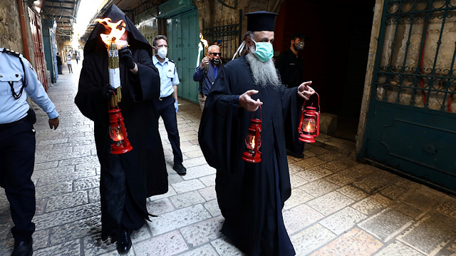 Bir Ortodoks Hristiyan din adamı,  sokaklarda ateş ve mumlarla koronavirüsten korumak amacıyla ayin düzenliyor.