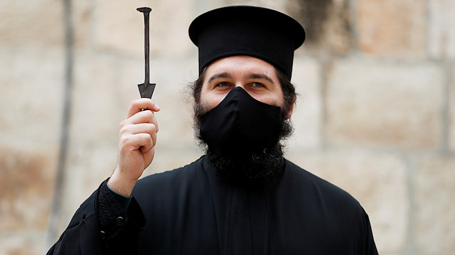 FILE PHOTO: An Orthodox Christian clergyman wearing a face mask holds up the traditional key to the Church of the Holy Sepulchre on the day that Greek Orthodox church authorities celebrate Good Friday amid the coronavirus disease (COVID-19) outbreak, in Jerusalem's Old City April 17, 2020 REUTERS/ Ammar Awad/ FIle Photo


