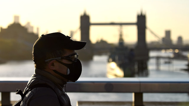 File photo: A man is seen wearing a protective face mask as he walks over London Bridge