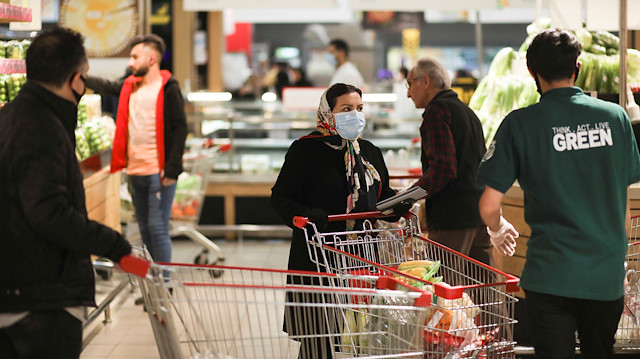 A woman wears a protective face mask as she shops at a supermarket