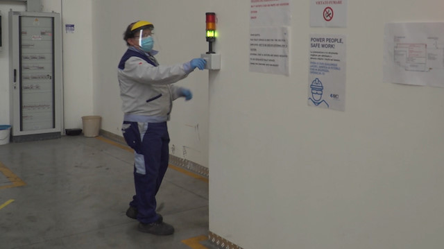 A worker is seen by a traffic light limiting the access to bathrooms inside the ISA factory that has introduced new safety measures to respect social distancing among workers to stop the spread of the coronavirus disease (COVID-19) in Bastia Umbra, Italy, April 22, 2020, in this still image taken from video. REUTERS TV via REUTERS

