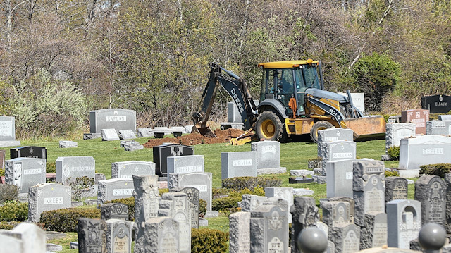 New York'ta kepçelerle mezar yerleri kazılıyor.