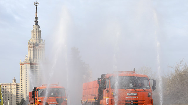 Vehicles spray disinfectant while sanitizing a road near the main building of the Lomonosov