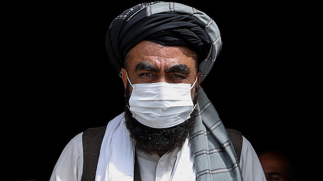 An Afghan man wears a protective face mask during free food donation