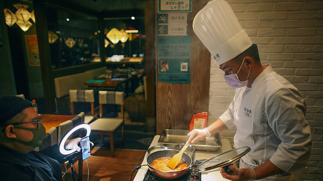 A chef wearing a face mask conducts a cooking lesson through a live-streaming session inside a restaurant at a shopping complex, as the country is hit by an outbreak of the novel coronavirus (COVID-19), in Tianjin, China March 8, 2020. 