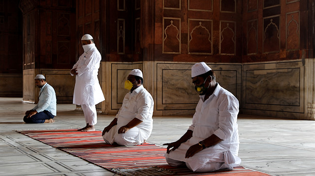 Muslim men wearing masks offer prayers at Jama Masji