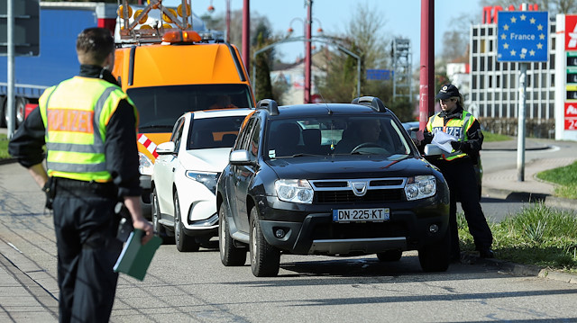 FILE PHOTO: A German police officer checks a car at the border with France due to the spreading of the coronavirus disease (COVID-19) in Saarbruecken, Germany, March 16, 2020.