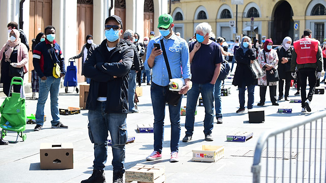 People wearing protective face masks queue at Porta Palazzo market in Turin after it reopened with social distancing rules as Italy begins a staged end to a nationwide lockdown, following the outbreak of the coronavirus disease (COVID-19), Turin, Italy, May 4, 2020. 