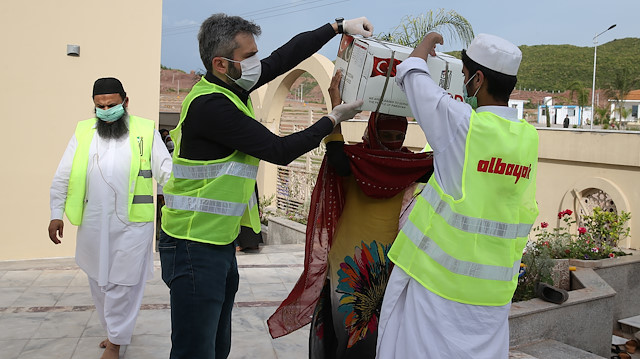 Albayrak Grubu Pakistan yetkilisi Cemil Şenocak, gıda kolilerinin dağıtımında.