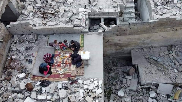 Beyaz Baretliler, molozların arasında iftar yapan Suriyelilerin görüntülerini paylaştı. 