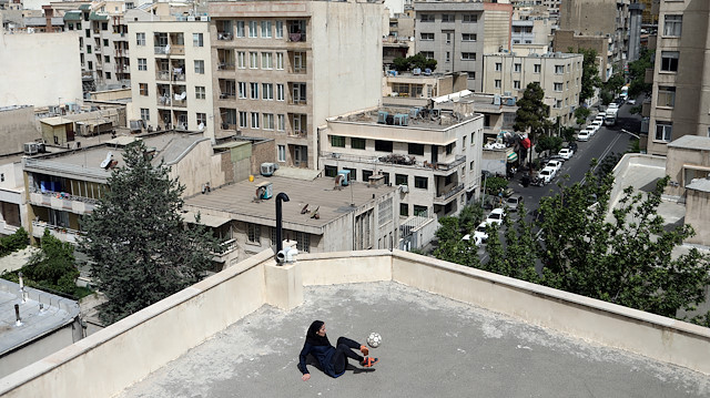 Iranian freestyle footballer Hosna Mirhadi, 23, trains with a ball at the rooftop of a building
