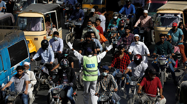 A traffic police officer wears protective gloves as he waves to control the traffic