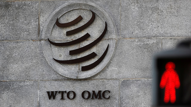 A logo is pictured outside the World Trade Organization (WTO) headquarters next to a red traffic light in Geneva, Switzerland