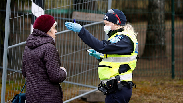 File photo: An Estonian police officer stops a woman at border crossing point as Estonia reintroduces border control and a ban to enter Estonia for foreigners as a preventive measure against the coronavirus disease (COVID-19) in Valga, Estonia March 17, 2020