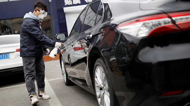 FILE PHOTO: A staff member disinfects a vehicle at a service centre of car-hailing service Didi Chuxing, as the country is hit by an outbreak of the new coronavirus, in Beijing, China February 27, 2020