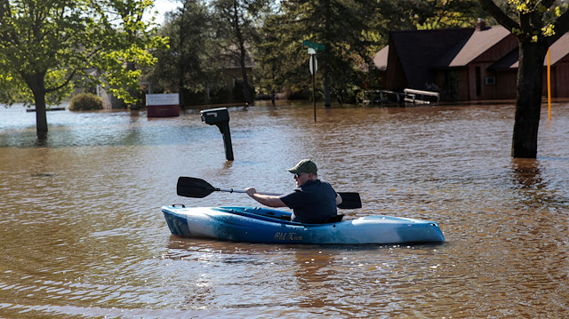 Resident Joe Ryan paddles a kayak to check on his home in a flooded neighborhood along the Tittabawassee River, after the two dam failures in Midland, Michigan, U.S., May 20, 2020. 