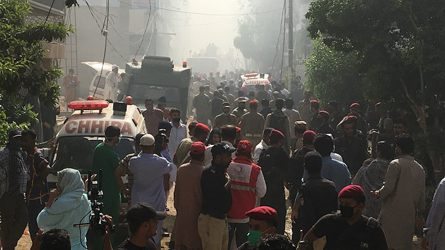 Ambulances and fire brigade vehicles gather at the site of a passenger plane crash in a residential area near an airport in Karachi, Pakistan May 22, 2020. 