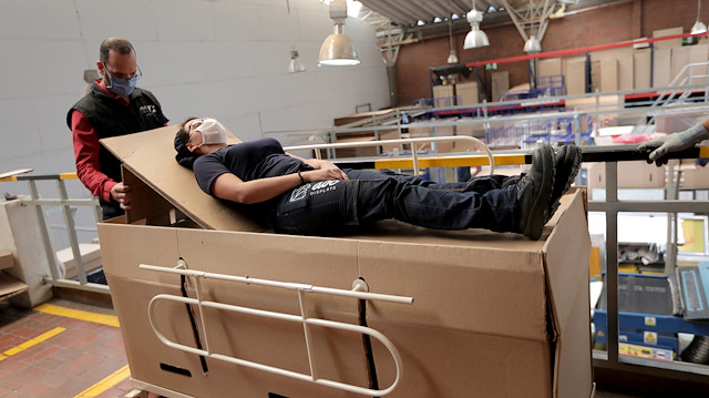 Rodolfo Gomez, a manager of the company "ABC Display" demonstrates how a hospital bed that the company manufactures is transformed into a cardboard coffin, amid the coronavirus disease (COVID-19) outbreak in Bogota, Colombia May 21, 2020