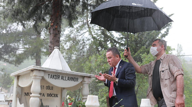 Antalya Büyükşehir Belediye Başkanı Muhittin Böcek'in dua ederken korumasının kendisine şemsiye tuttuğu ancak korumanın sırılsıklam olduğu an...