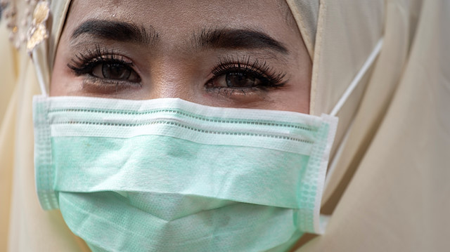 A Muslim woman wearing a face mask looks on as she celebrates Eid al-Fitr, the Muslim festival marking the end of the holy fasting month of Ramadan, at the Thai Islamic Center amid the spread of the coronavirus disease (COVID-19) outbreak in Bangkok, Thailand, May 24, 2020. REUTERS/Athit Perawongmetha

