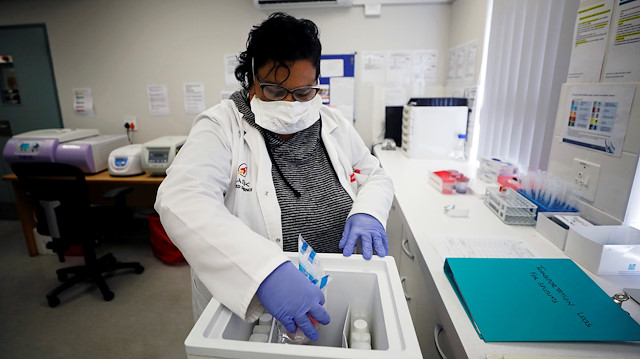 A medical researcher studying the BCG vaccine for tuberculosis examines test samples in a laboratory run by South African biotech company TASK in Cape Town, South Africa, May 11, 2020