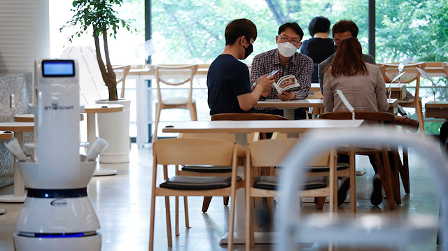 Customers wait at a cafe where a robot that takes orders, makes coffee and brings the drinks straight to customers is being used in Daejeon, South Korea, May 25, 2020