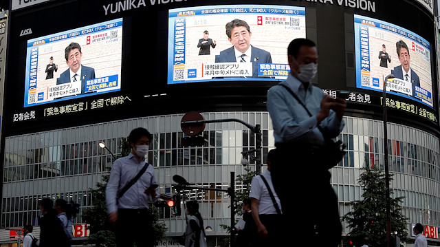 Large screens on a building show live broadcast of Japan's Prime Minister Shinzo Abe's news conference on the lifting of the state of emergency in Tokyo and the remaining 5 areas still under alert for the coronavirus disease (COVID-19) at Shinjuku district in Tokyo, Japan May 25, 2020. 