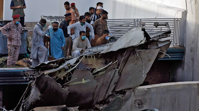 File photo: People stand next to the debris of a plane after crashed in a residential area near an airport in Karachi, Pakistan May 22, 2020. 