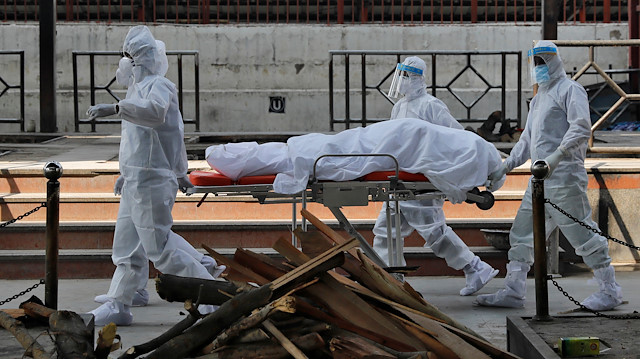Health workers in protective suits push a stretcher with the body of Virendra Gupta, who died due to the coronavirus disease (COVID-19), for his cremation at the Nigambodh Ghat crematorium in New Delhi, India, June 1, 2020