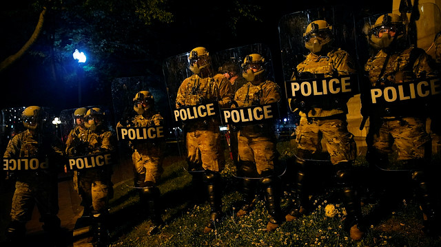 DC National Guard military police officers look as demonstrators rally 