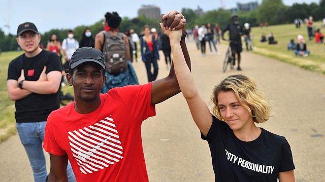 A man and a woman hold hands aloft in Hyde Park during a "Black Lives Matter" protest following the death of George Floyd who died in police custody in Minneapolis, London, Britain, June 3, 2020