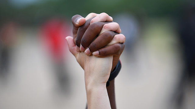 A man and a woman hold hands aloft in Hyde Park during a "Black Lives Matter" protest following the death of George Floyd who died in police custody in Minneapolis, London, Britain, June 3, 2020.