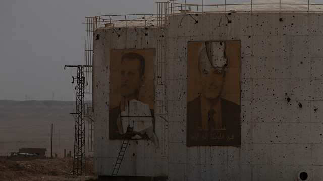 Damaged pictures of Syria's Bashar al-Assad and his father, former president Hafez 