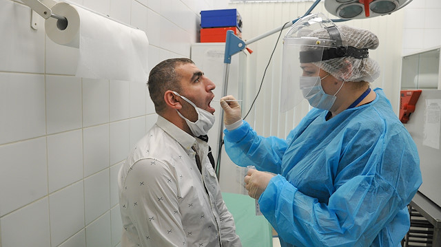 File photo: A medical specialist wearing protective gear takes a swab from a man at Sheremetyevo International Airport amid the outbreak of the coronavirus disease (COVID-19) outside Moscow, Russia June 4, 2020. Alexander Avilov/Moscow News via Reuters