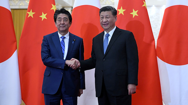 File photo: Japan's Prime Minister Shinzo Abe shakes hands with China's President Xi Jinping