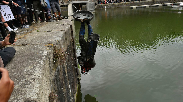 Göstericiler yıktıkları heykeli nehre attı. 