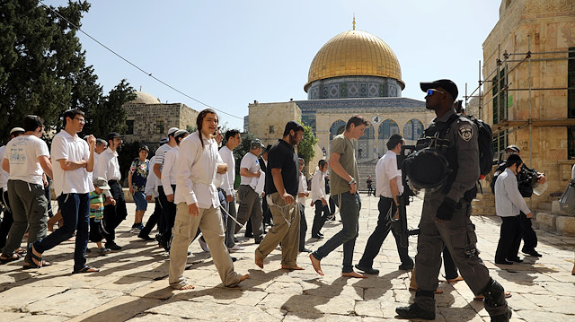 An Israeli policeman guards next to Jewish visitors